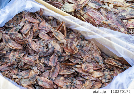 a lot of brown squids that have been placed in a plastic bag to dry in the sun. It is not uncommon for people to dry seafood in this way. 118270173