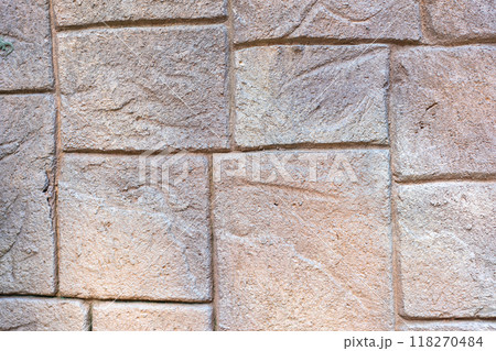 The stone wall is patterned in light brown tones, each cube is different, small and large alternately. 118270484