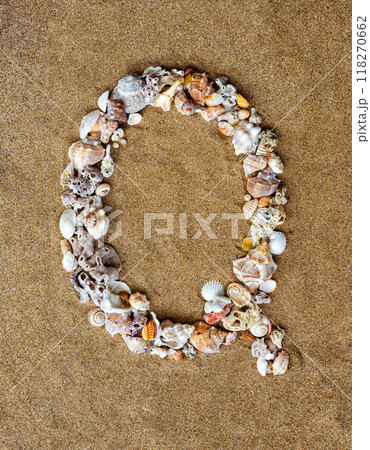 The letter Q of the English alphabet, a letter made of seashells on the sand. The letter Q of the English alphabet, a letter made of seashells on the sand. 118270662