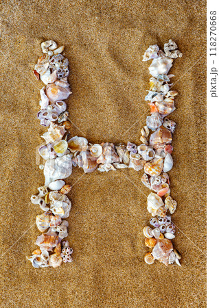 The letter H of the English alphabet, a letter made of seashells on the sand. The letter H of the English alphabet, a letter made of seashells on the sand. 118270668