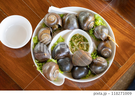 Brown shelled sweet snails Put them on a white platter alongside some more vegetables. Consume seafood sauce. Brown shelled sweet snails Put them on a white platter alongside some more vegetables. Consume seafood sauce. 118271009