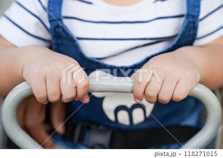 Youngster sitting on an adult bike and gripping the handle Youngster sitting on an adult bike and gripping the handle 118271015
