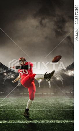 Poster. Player kicks football with forceful swing, mid-action, with stadium lights casting epic glow across field. 3D render of stadium. Poster. Player kicks football with forceful swing, mid-action, with stadium lights casting epic glow across field. 3D render of stadium. 118272364
