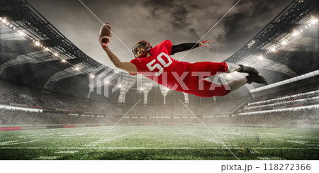 Player dives forward, fully stretched, as he reaches out to catch ball against background of stadium full of energetic spectators. 3D render of stadium. 118272366