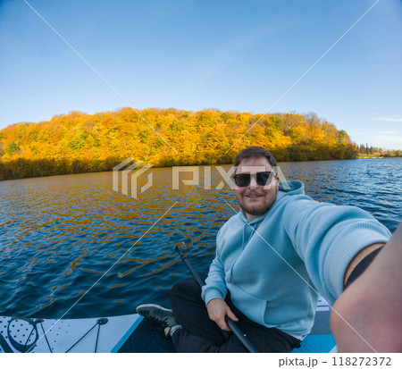 Man on Paddleboard Surrounded by Autumn Colors 118272372