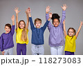 group of cheerful children pulled his hands up in white wall 118273083