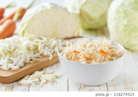 fermented white cabbage with carrot in a white bowl on the table. fermented white cabbage with carrot in a white bowl on the table. 118274525