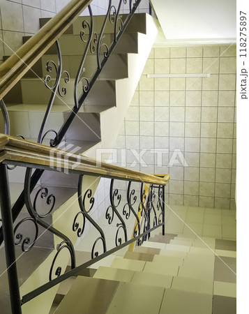 Close-up view of the staircase with vintage wrought iron railings and ceramic tile steps, vertical 118275897