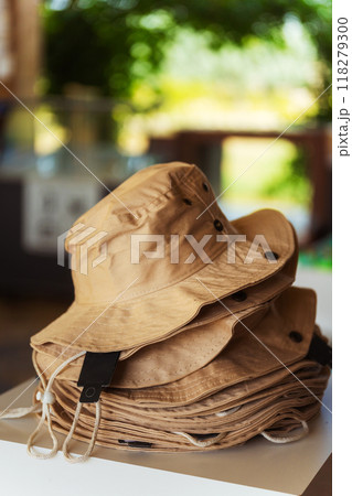 There is a stack of various hats nicely sitting on top of each other on a table There is a stack of various hats nicely sitting on top of each other on a table 118279300