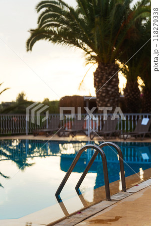 A beautiful swimming pool featuring a palm tree in the background 118279338