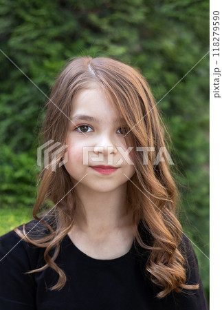 Fashion portrait of a beautiful little girl with makeup and hairstyle outdoors 118279590