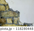 Exposed brick wall with cracked plaster detail 118280448
