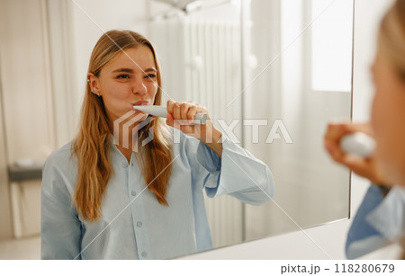A Young Woman Engaging in Brushing Her Teeth in a Contemporary and Stylish Bathroom A Young Woman Engaging in Brushing Her Teeth in a Contemporary and Stylish Bathroom 118280679