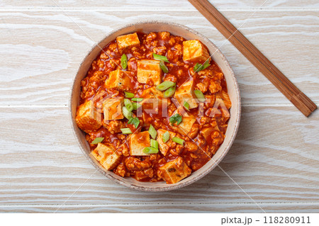 Mapo tofu garnished with green onions in bowl top view, traditional Chinese dish, on white wooden background 118280911