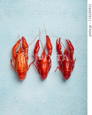 Three whole cooked crawfish lying on blue background top view 118280912