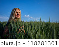 Smiling female Farmer standing on Wheat Fields and looking forward 118281301