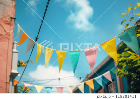 Triangular pennant colored flags like of garland on blue sky background, decoration for holiday or party Triangular pennant colored flags like of garland on blue sky background, decoration for holiday or party 118281411