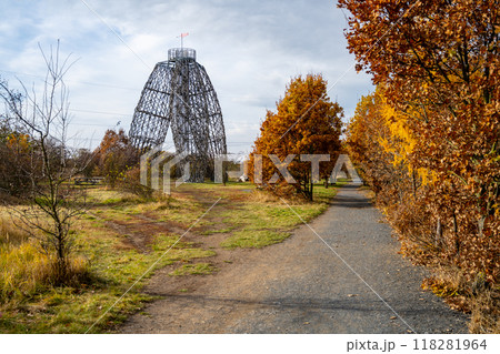 The Doubravka Lookout Tower stands tall amidst vibrant autumn foliage in Prague, providing a scenic view of the surrounding landscape on a tranquil day. 118281964