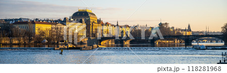 On an autumn morning, the Vltava embankment in Prague showcases the Czech National Theatre bathed in warm light. The tranquil river reflects the surrounding historic architecture. On an autumn morning, the Vltava embankment in Prague showcases the Czech National Theatre bathed in warm light. The tranquil river reflects the surrounding historic architecture. 118281968