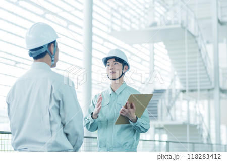 現場で打ち合わせをするヘルメットを着用した作業員 118283412