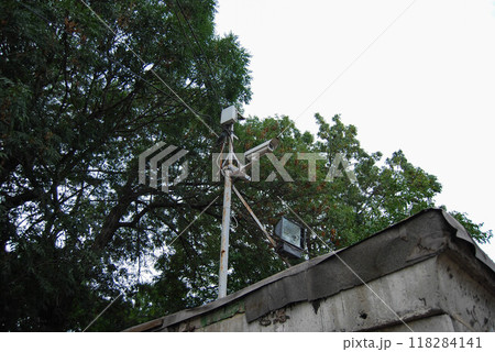 A metal pole with electrical communications and street lighting.A metal pillar against the sky, with CCTV cameras and lighting equipment installed on it. 118284141