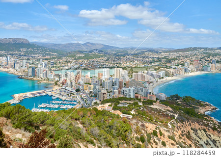 Breathtaking Aerial View Calpe Spain Mediterranean Coastline Penon de Ifach Rock Lush Vegetation Sunny Day Tourism Paradise, Panoramic Vista Calpe Costa Blanca Turquoise Waters Golden Beaches Iconic 118284459