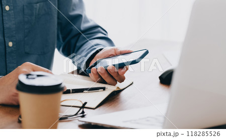 スマホを操作する男性の手元 118285526
