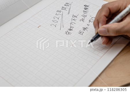 2025年問題についてきれいな字で原稿用紙に書き出している 118286305