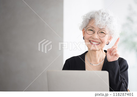 営業するシニア(高齢者)女性のイメージ ポイントやオススメの指差しポーズ 左にコピースペースあり 営業するシニア(高齢者)女性のイメージ ポイントやオススメの指差しポーズ 左にコピースペースあり 118287401