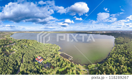 Big lake with green shores in bright sun light and city on horizon, aerial landscape. Recreation concept. Aerial view 118289267