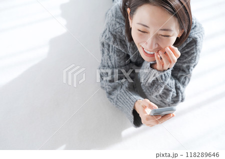 リビングの床に寝転ぶ女性 118289646