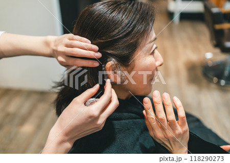 美容室でヘアカラーの準備でイヤーキャップをされる50代女性 118290273