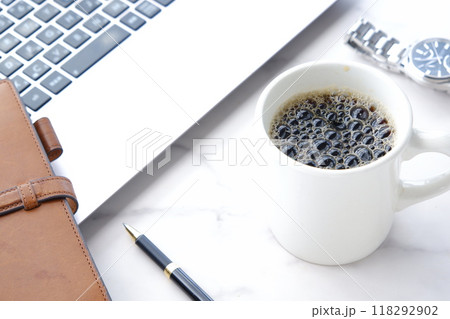 淹れたての美味しいコーヒーを飲みながら、ノートパソコンでデスクワークをしているイメージ 118292902