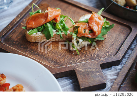 Sandwich with red fish and green salad on a wooden tray. Sandwich with red fish and green salad on a wooden tray. 118293020