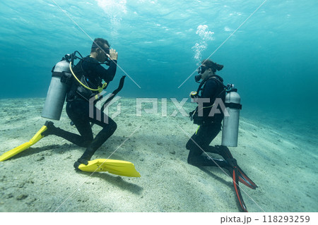 Diving instructor trains a novice who is learning to dive , underwater , Red sea . Diving instructor trains a novice who is learning to dive , underwater , Red sea . 118293259