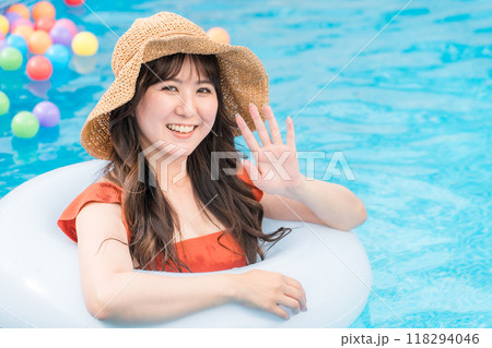 浮き輪でプールに入って遊ぶ若いアジア人女性（バカンス・リゾート・バケーション・海外旅行） 118294046