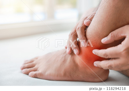 A man injured his ankle and it was swollen and red. Causes of pain include Ankle sprain, Gout, Rheumatoid arthritis, office syndrome, numbness, and cramp symptoms. Healthcare medical concept. 118294218
