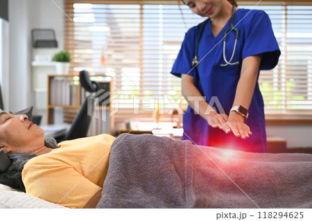 Mature woman undergoing alternative therapy treatment, therapist hands over woman stomach. Reiki technique concept 118294625
