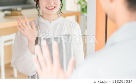 朝出勤する夫・旦那を笑顔で見送りする若いアジア人女性・妻 118295034