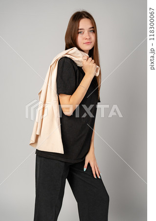 Woman Standing in Black Shirt and Pants on gray background 118300067