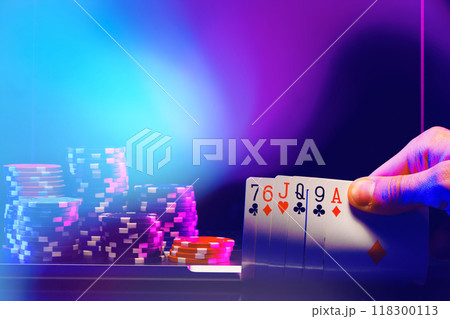 Hand of Cards and Stacks of Poker Chips in a Casino Setting Hand of Cards and Stacks of Poker Chips in a Casino Setting 118300113