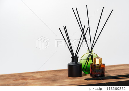 Black And Brown Glass Reed Diffuser Bottles On Wooden Surface 118300282
