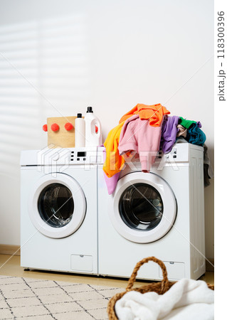 Modern Laundry Room With White Appliances and Greenery Modern Laundry Room With White Appliances and Greenery 118300396