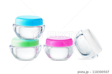 Clear cosmetic jars stacked with lids on a plain background 118300507