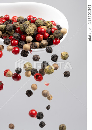 Different types of peppercorns pouring. Red, green, white and black pepper. 118301561
