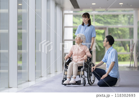 シニア女性と男女の介護スタッフ 118302693