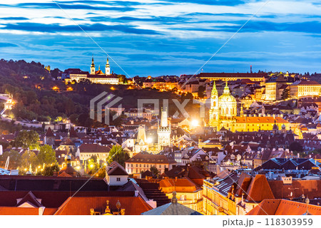 The skyline of Prague showcases the stunning architecture of Lesser Town and Strahov Monastery illuminated as evening descends over the city, creating a magical atmosphere. 118303959