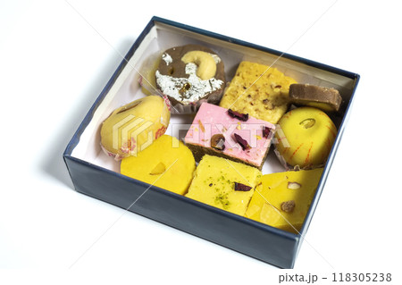 Traditional various Indian mixed sweets made of milk in cardboard box on white surface. 118305238