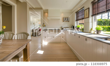 Bright Kitchen with White Cabinets and Wooden Dining Table 118308975