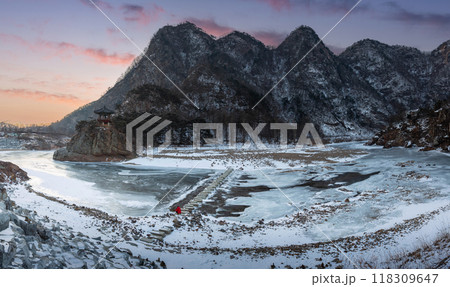 Snow capped mountains and frozen rivers on a clear day in winter in sunset, South Korea. Snow capped mountains and frozen rivers on a clear day in winter in sunset, South Korea. 118309647